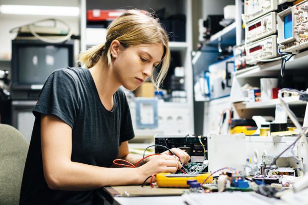 female-engineer-measuring-voltage-on-conductor-board